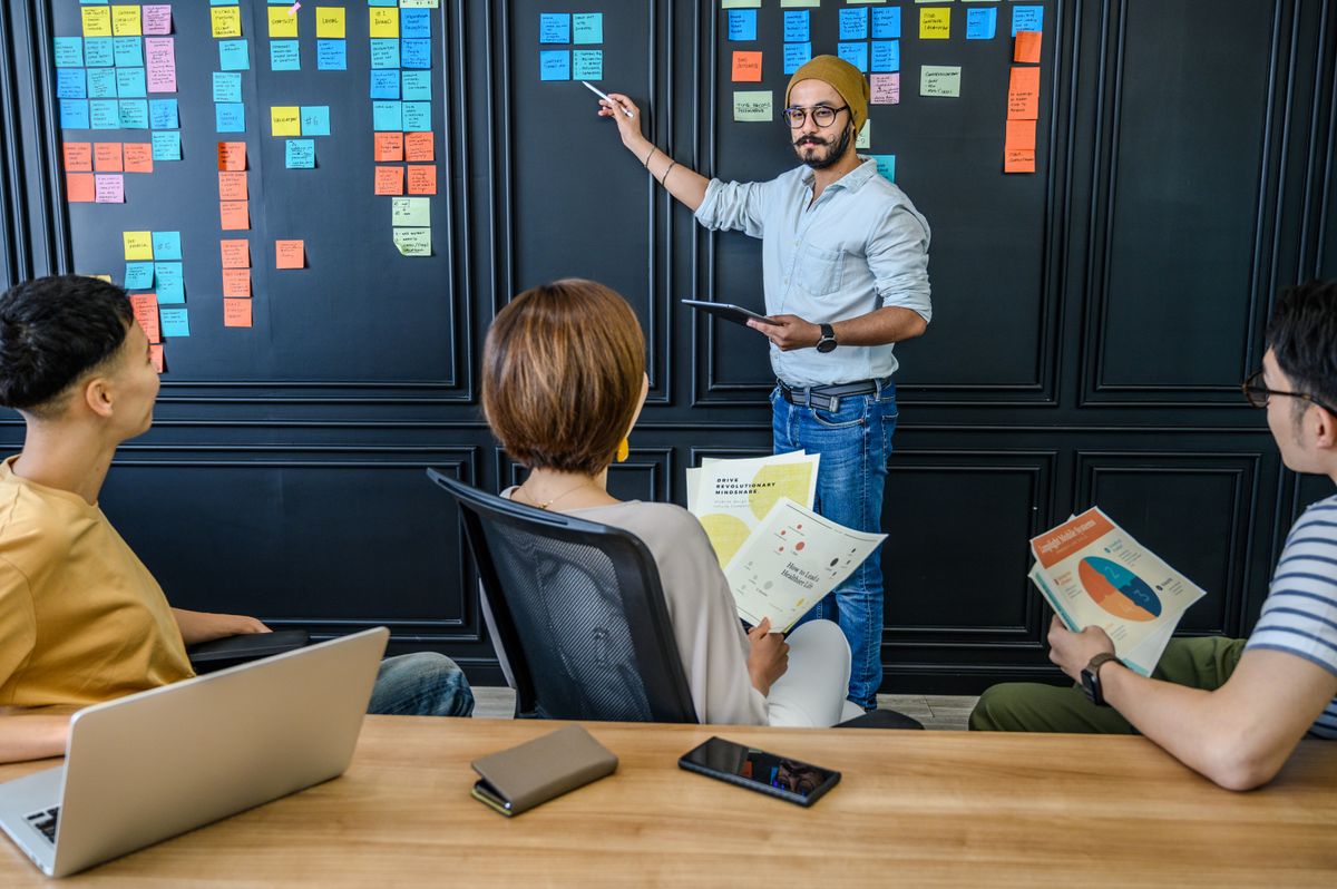A team discussing a workflow using sticky notes